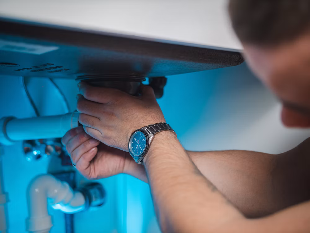 Técnico trabajando en una tubería empotrada en la pared